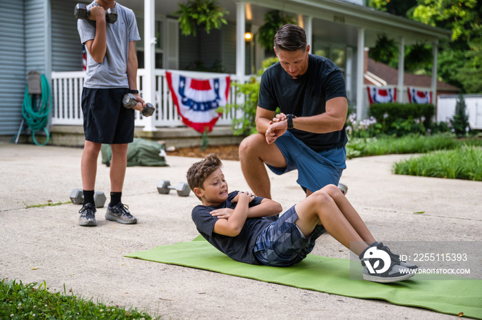 Air Force service member trains with his sons in a morning workout in preperation for a PT fitness test.