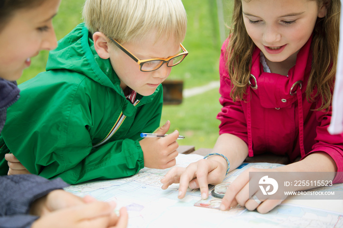 elementary students using navigation tools outdoors