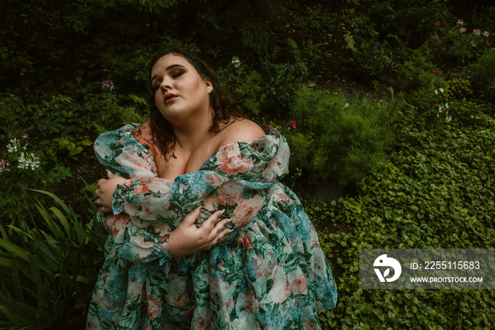 portrait of a plus size woman hugging self