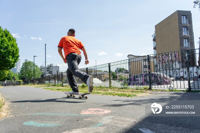 Young man skateboarding on footpath