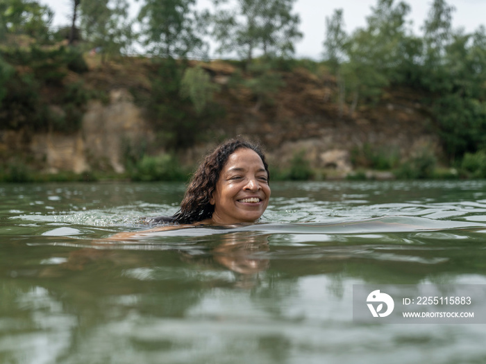 Smiling woman swimming in lake