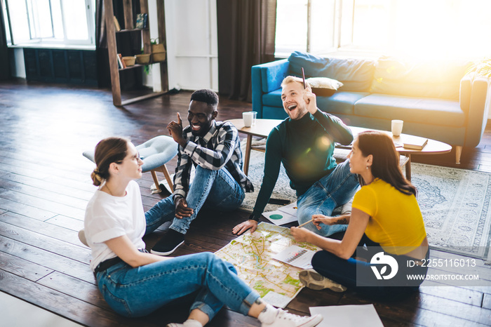 Joyful multiracial friends spending time together in cozy living room