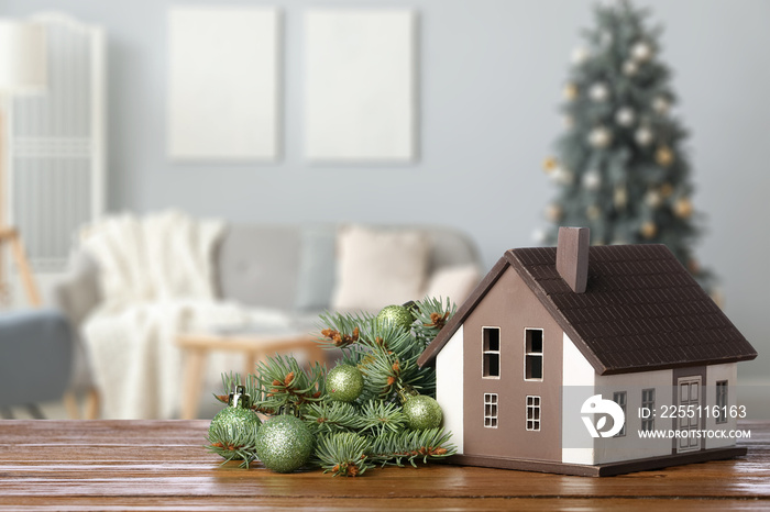 Model of house with Christmas decorations on table in room. Concept of real estate