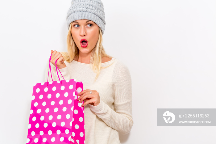 Happy young woman holding a shopping bag on a white background