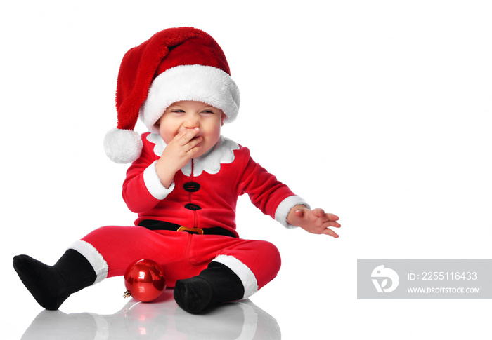 Little child boy toddler in santa claus christmas costume and hat happy smiling ready to celebrate new year party