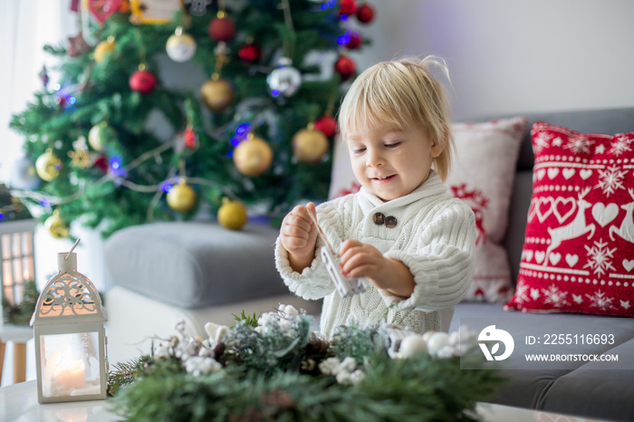 Little cute blonde toddler boy, making advent wreath at home