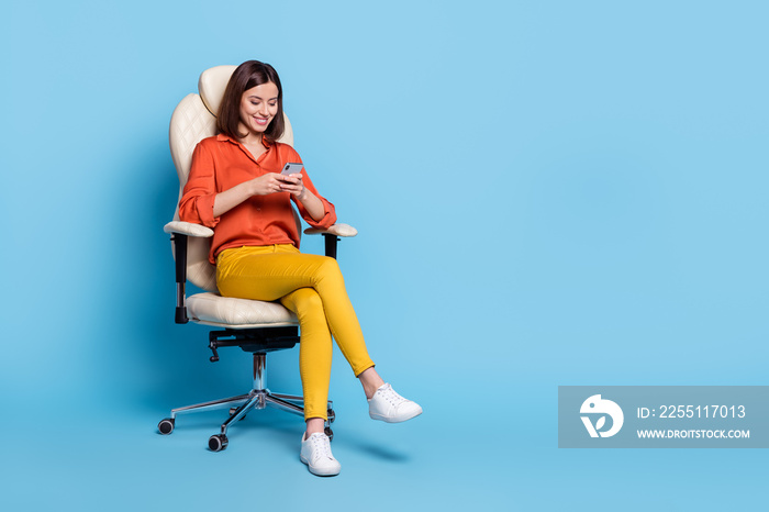 Full size photo of young lovely lady sit stool use cellphone type comment share app download isolated over blue color background