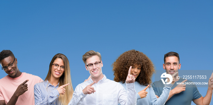 Composition of group of friends over blue blackground smiling and looking at the camera pointing with two hands and fingers to the side.