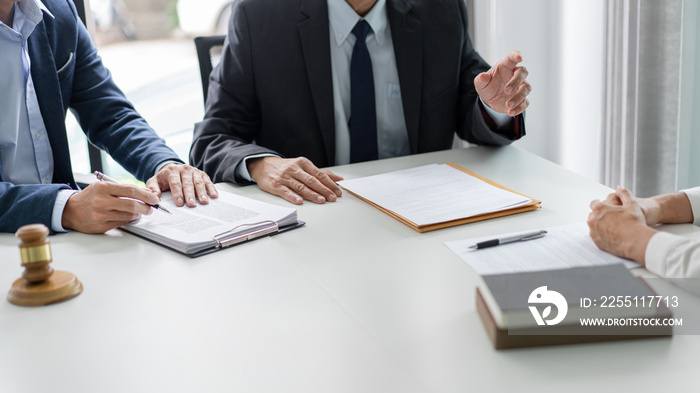 law concept the businessman, a man with the black suit, having a law consultation with the law officer, a man in deep blue suit and his assistant, a man in white shirt