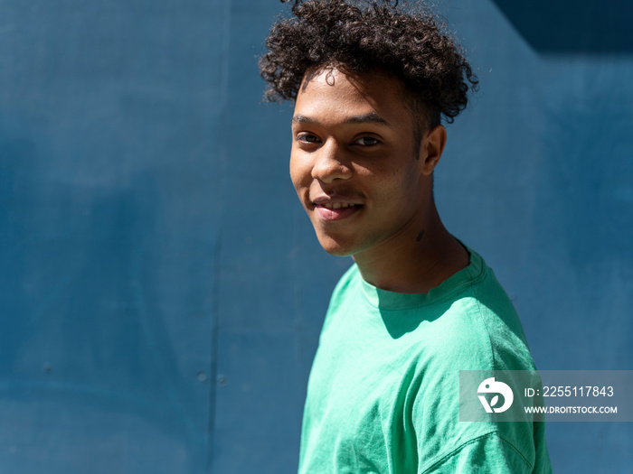 Portrait of smiling man against blue wall