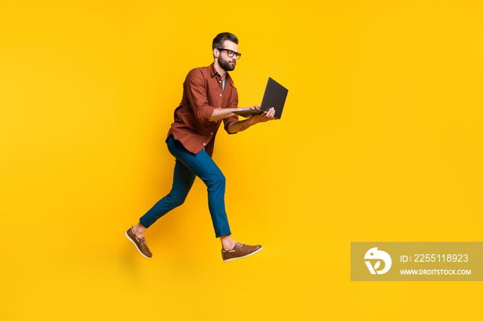 Full length body size photo of freelancer in glasses working on computer typing texting isolated on vivid yellow color background