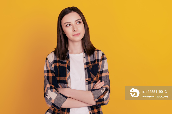 Photo of confident thoughtful creative lady folded hands look empty space isolated yellow color background