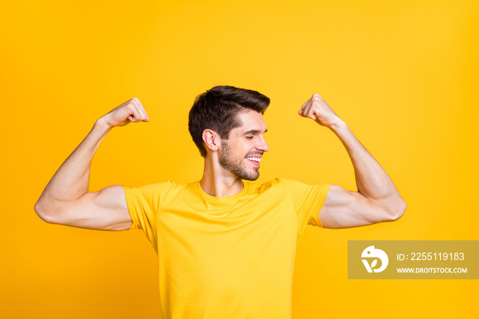 Close-up portrait of his he nice attractive content strong sportive cheerful cheery guy demonstrating muscles isolated over bright vivid shine vibrant yellow color background