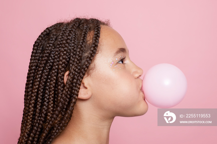 Profile of girl blowing bubble gum