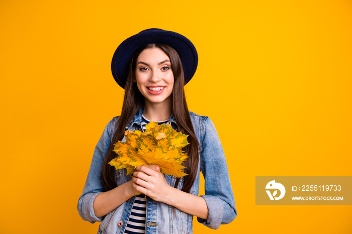 Portrait of her she nice-looking attractive lovely winsome charming cute cheerful cheery straight-haired lady holding in hands leaves isolated over bright vivid shine yellow background