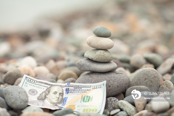 Pyramid of stones and dollar banknotes.