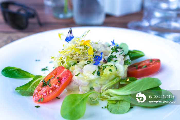 Tantilising amberjack ceviche with tomatoes and micro herbs served at a restaurant in Ibiza