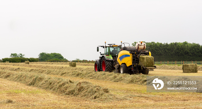 Tractor on farm bailing straw