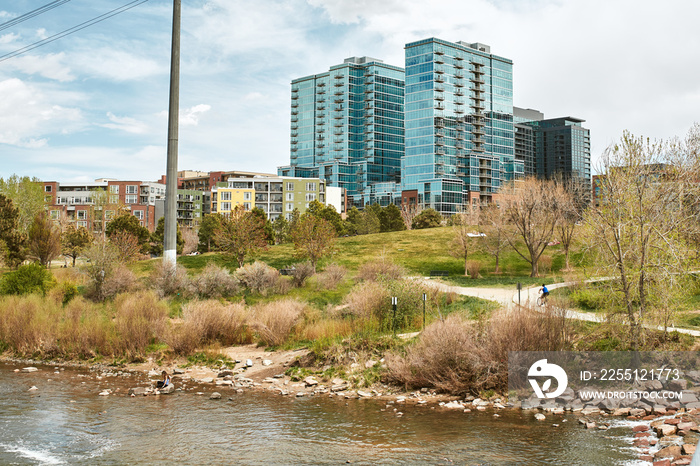 Landscape view of Commons Park with apartments and office buildings in the distance in lower Downtown Denver, Colorado