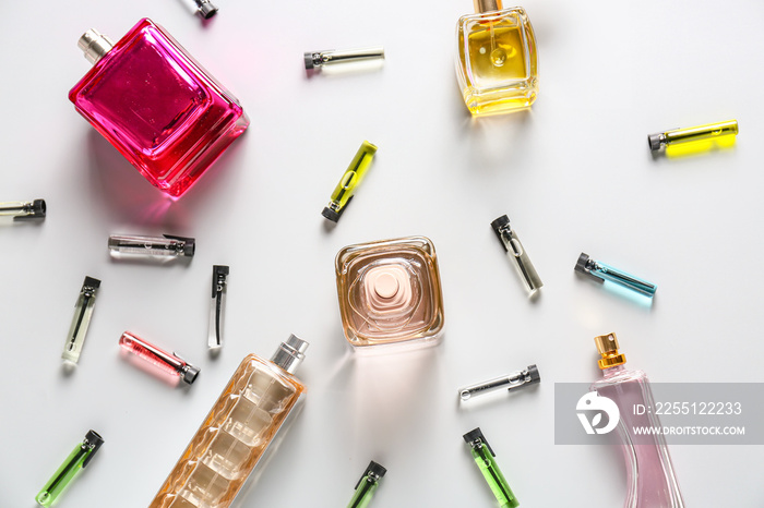 Bottles of different perfumes on light background