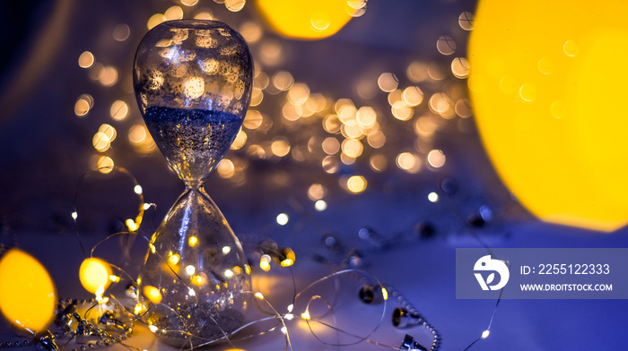 Christmas background, hourglass with silver sand. Vacation approaching concept. Happy New Year