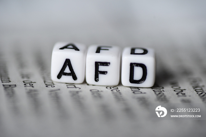 Word AFD formed by wood alphabet blocks on newspaper german party politics