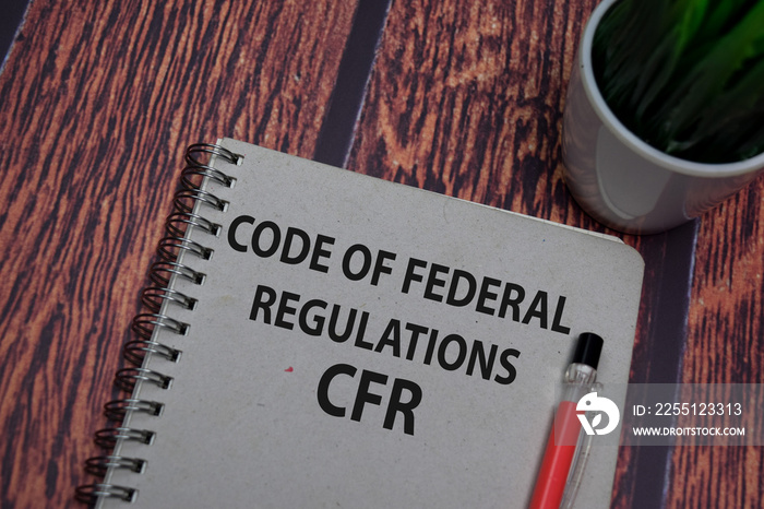 Book about Code Of Federal Regulations - CFR isolated on wooden table.