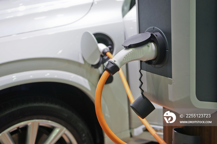 Electric car charging on parking lot with electric car charging station.