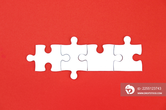 White puzzle pieces on red background, copy space for text.