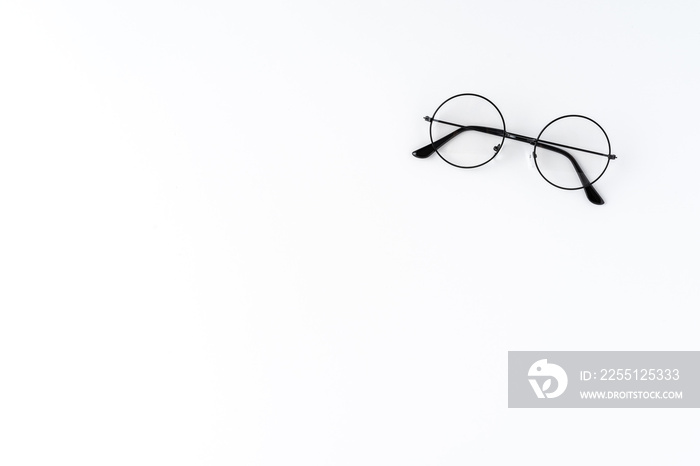 Overhead shot of round eyeglasses on white table with copyspace