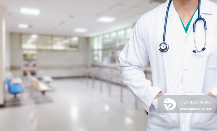 smart doctor with a stethoscope around his neck with abstract blurred image of empty chairs in waiting room at hospital background, health care and medical technology concept