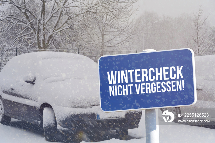 Winter, ein Auto und ein Schild mit dem Aufdruck Wintercheck Nicht Vergessen