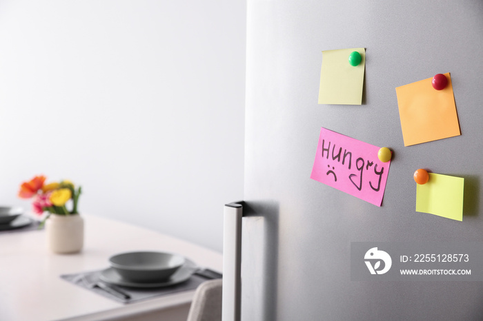 Papers with magnets on fridge door