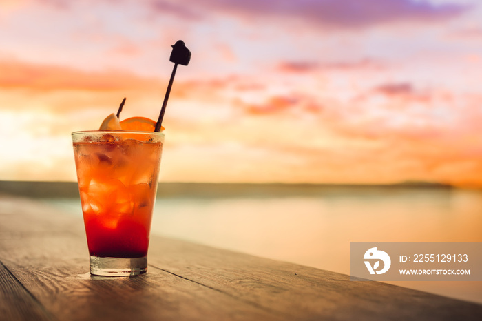 Mocktail on the table near swimming pool and sunset cloud.