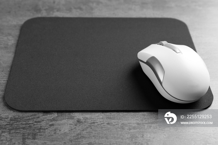 Blank mat and wireless mouse on textured background