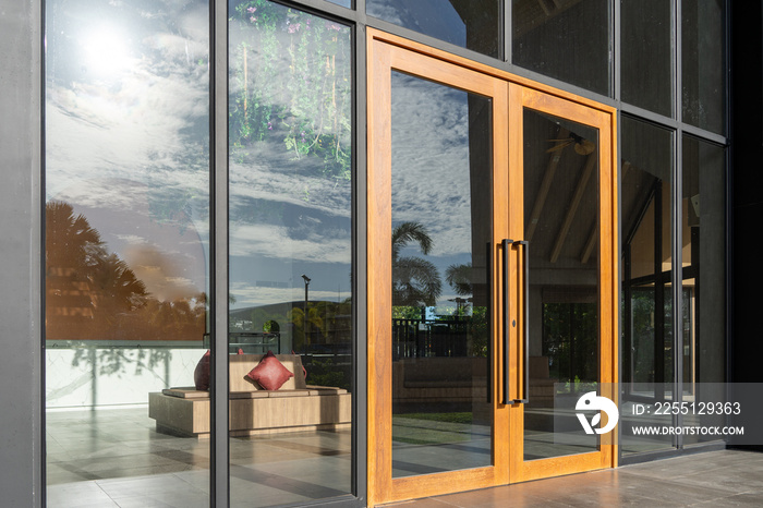 Glass door entrance to a large apartment hotel, the material is wood and steel, beautifully decorated.