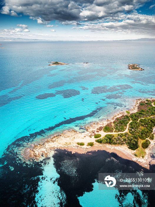 Drone view of the sandy Karydi beach in the resort village of Vourvourou in Greece. Incredible patterns of different colors on calm sea water