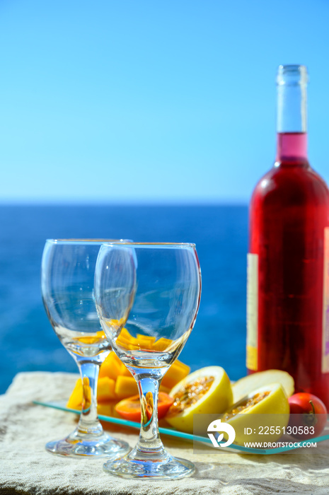 Two glasses with rose wine served outdoor with exotic fruits on tropical island La Palma, Canary islands, Spain with beautiful blue ocean view