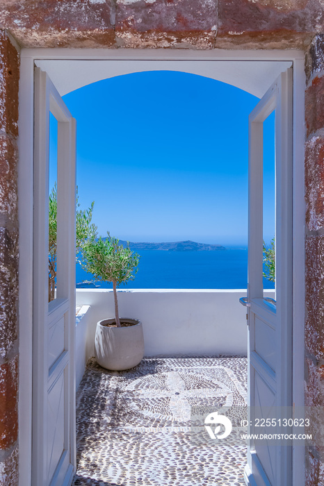 Vue de la caldeira à Santorin à travers une porte ouverte.