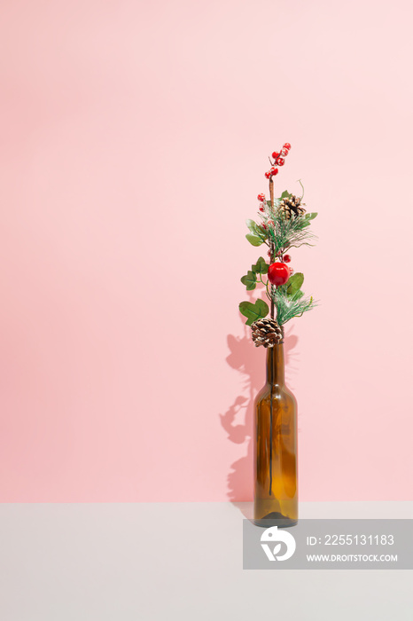 Minimal winter holidays composition with one decorative branch in a bottle. Christmas and New Year concept.