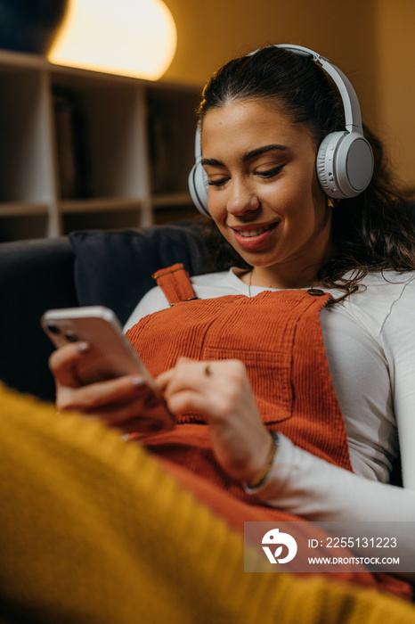 Teenage girl uses her phone at home and smiles