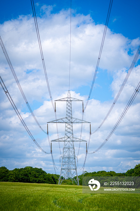 Pylon Power Electricity Electrical Distribution Aerial Cable Running through Countryside Farmer Fields with Blue Sky and White Clouds