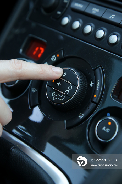 Hand ajusting the air conditioner in the car