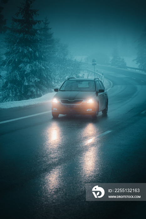 A car driving in heavy dark fog in the mountains on a cold winter day with snow. Harz Mountain, Harz National Park, Torfhaus, Germany