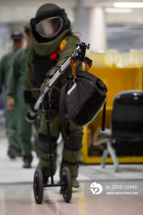 EOD officer in The explosive ordnance disposal suit take off the bomb bag with remote arm