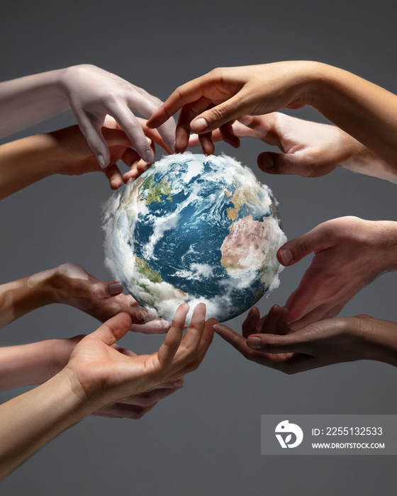 Hands holding, touching planet Earth, close up on grey background. Environment save, taking care of nature and ecology, supporting hands concept. Globe woldwide protection, traveling. Beauty.