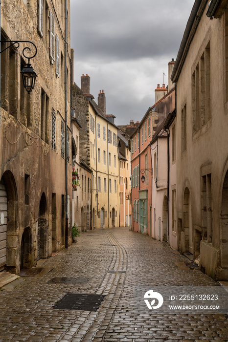 deserted city streets in the center of Dole with historic art nouveau buildings and cobblestone street under an overcast sky