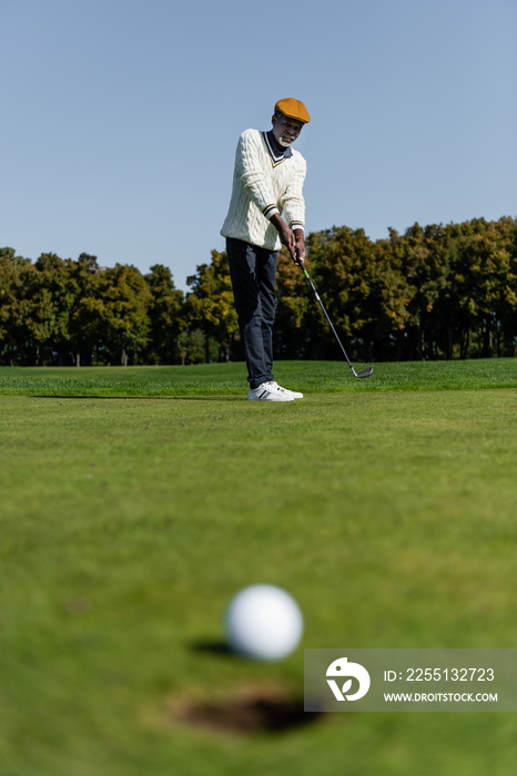 african american man playing golf on green field.