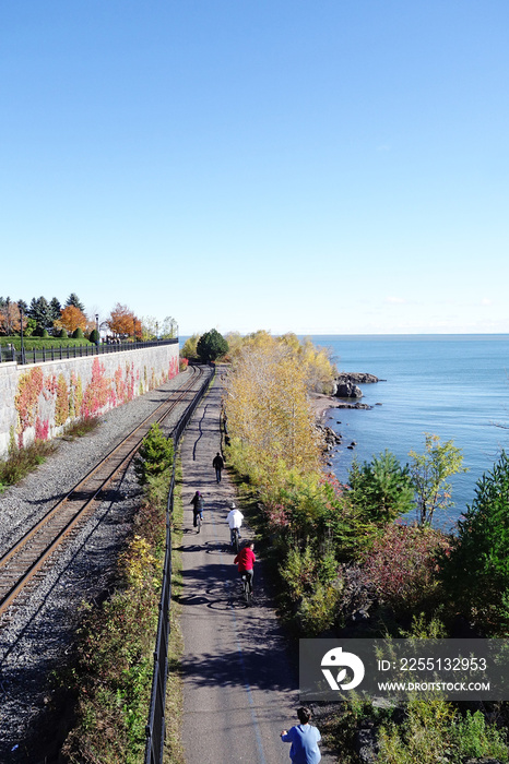 People bicycle and walk along a trail in Leif Erickson Park, along Lake Superior in Duluth Minnesota