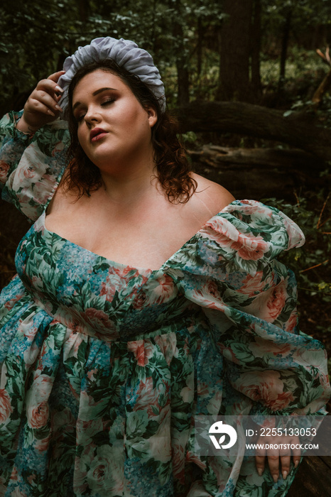 closeup of a plus size woman wearing a floral dress eyes closed